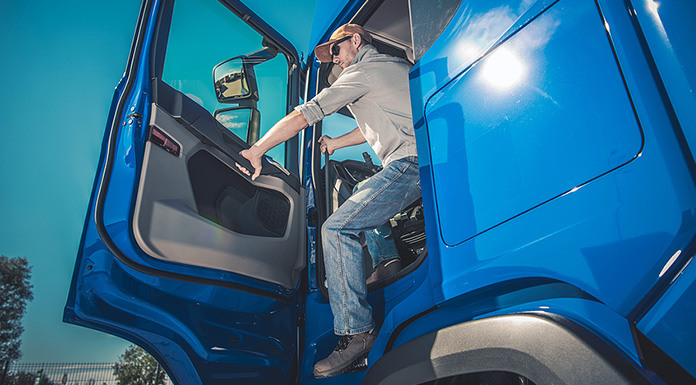 A driver safely existing his truck.